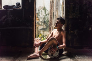 very beautiful barefoot and topless boy relaxing with soccer ball