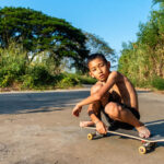 shirtless boy on skateboard