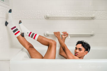 boy in classic tube socks laying in bathtub