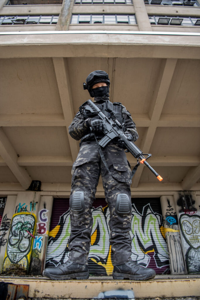 Miltary man with fake gun in front of graffiti