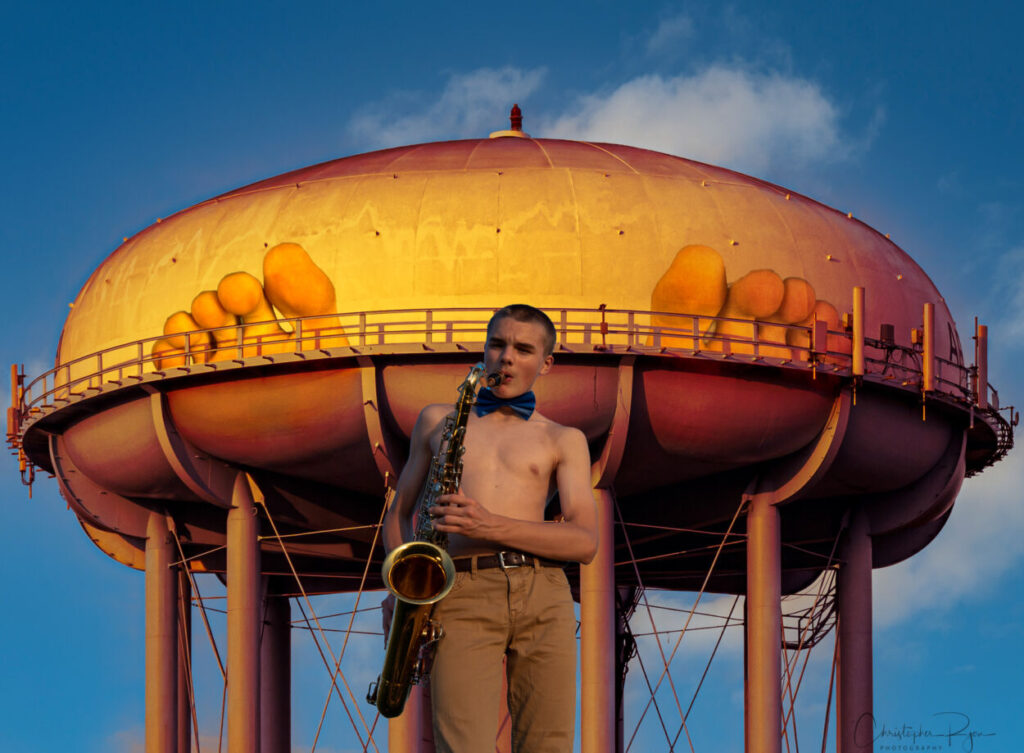 saxophone player with water tank feet in the background