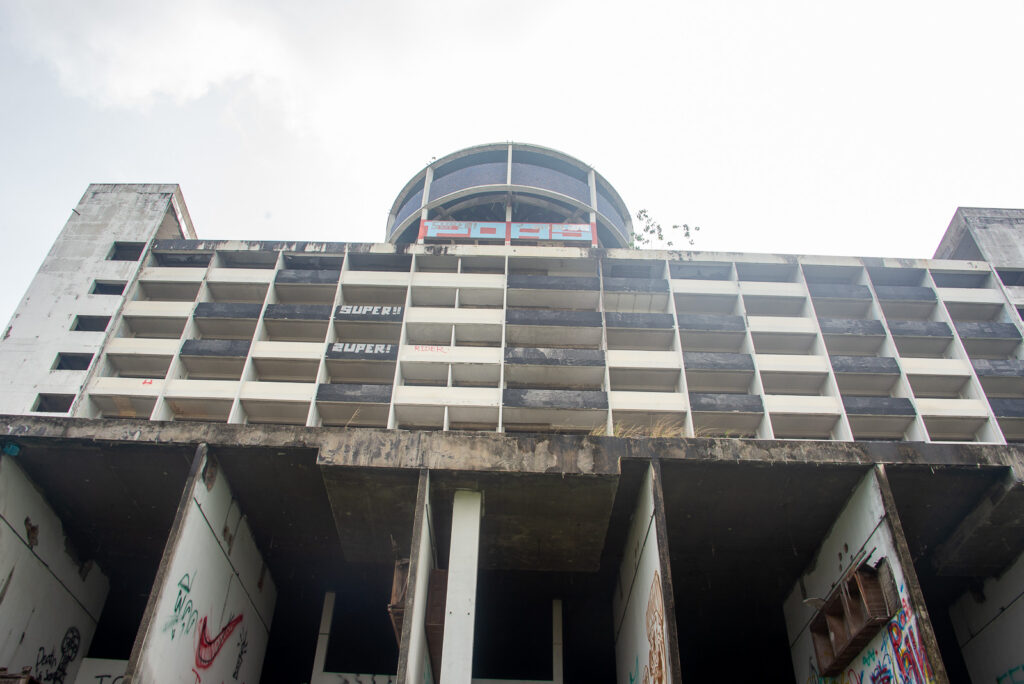 Low angle shot looking up at the abandoned brutalist Ghost Tower building in Chiang Mai.
